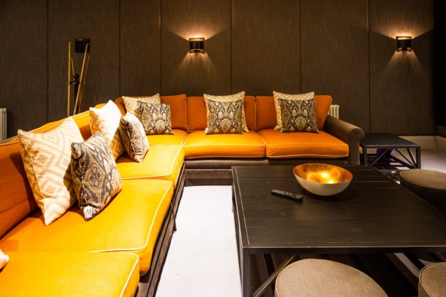 Room with L-shaped orange sofa and coffee table