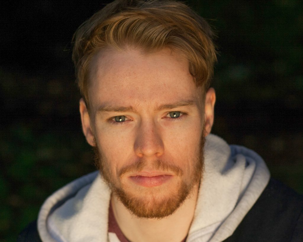 Red haired actor with bushy beard and blue eyes