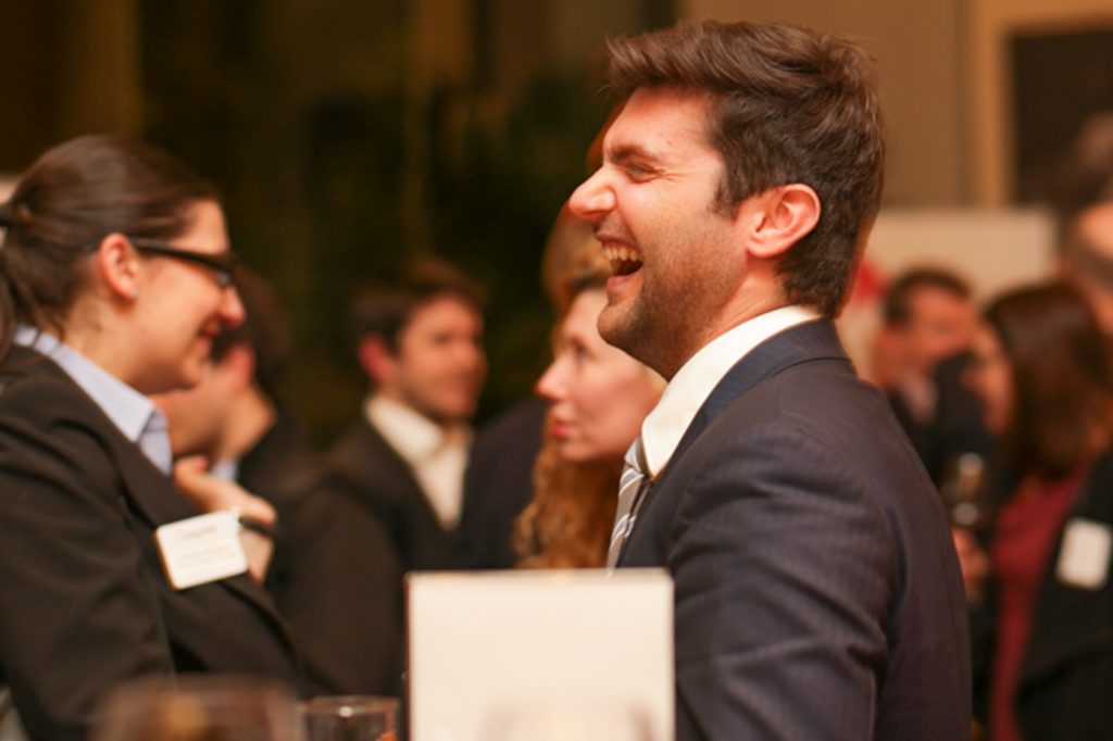 Man laughing in navy suit at corporate event