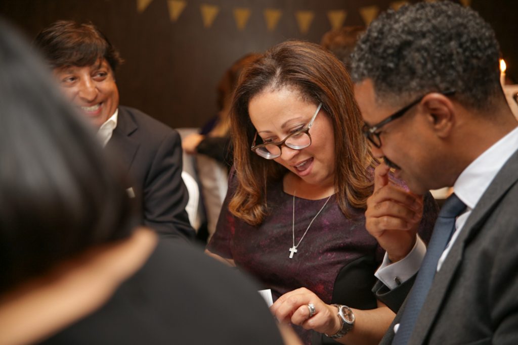 Woman showing document to men at corporate event